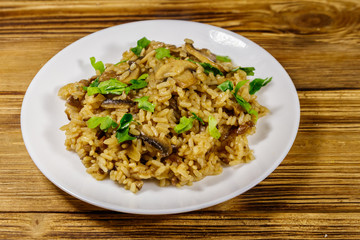 Tasty risotto with mushrooms on wooden table