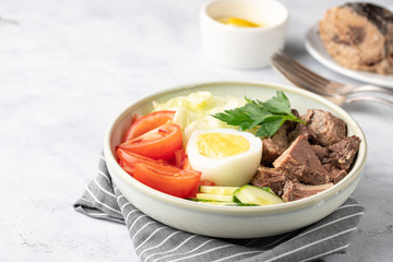 Salad with canned tuna, egg and vegetables - tomatoes, cucumber and lettuce.