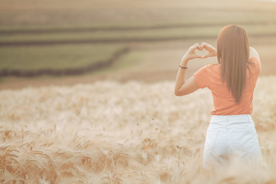 The maiden hand made a heart-shaped symbol over the golden barley fields in the morning to symbolize friendship, love, and compassion. Showing Love and Friendship over the Golden Barley Fields