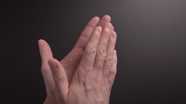 A man is sanitising his hand with hand sanitising gel in slow motion part1. Dark background. Plenty of space for text. Great video for educational purposes.