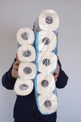 Toilet paper.Purchase and shortage of toilet paper.A man holds several packages  of toilet paper in...