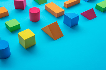 Set of colorful geometric cube or block toy on blue background with copy space. Abstract pattern...