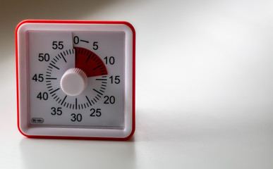 Red and white timer counting down on a clean white table