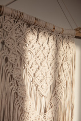Wall panel in the style of Boho made of cotton threads in natural color using the macrame technique for home decor and wedding decoration. Beautiful boho macrame wall panel will add a cozy atmosphere