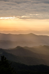 Obraz premium Layer of mountains and mist with ray of sunset