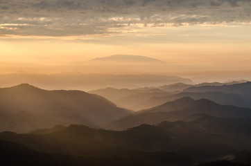Layer of mountains and mist with ray of sunset