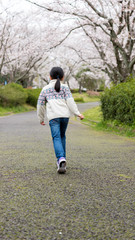 春の満開の桜の公園で遊んでいる可愛い子供