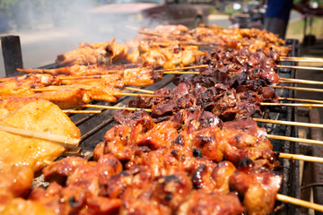 Roast chicken on a metal grill with charcoal