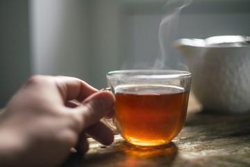 Cup of hot black tea. hand holding a Cup of tea. warming drink in winter