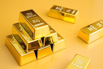 Gold bars or bullion stack on yellow background. Financial, global world economic or gold trading in commodity market concept. It performs well during global crises.