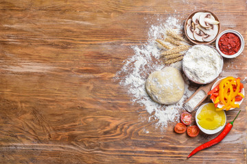 Ingredients for tasty pizza on wooden background