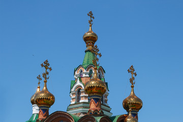 Fototapeta na wymiar Golden domes with crosses of the temple