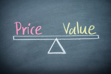 Obraz premium Text word price and value balance on seesaw drawing writing on chalkboard or blackboard background. Concept of price and value analysis in product, business and investment. Real photo.