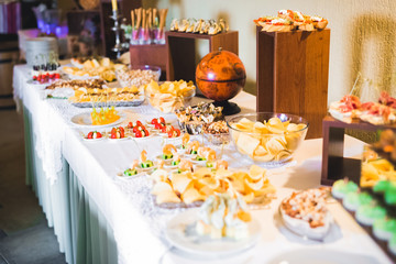 Delicious and tasty dessert table with cupcakes and shots at reception closeup