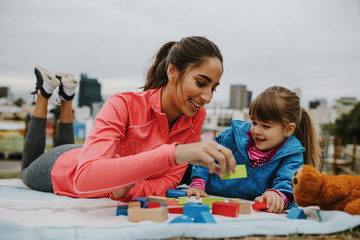 Girl and nanny playing wooden blocks