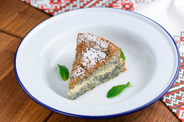 Fresh homemade poppy seed cake with vanilla cream and powdered sugar.