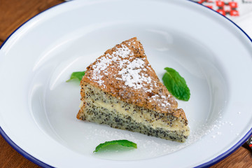 Fresh homemade poppy seed cake with vanilla cream and powdered sugar.