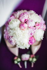 Pair of elegant and stylish bridal shoes with a bouquet with roses and other flowers