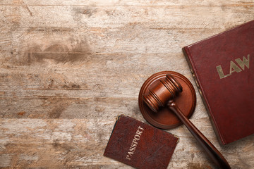 Judge's gavel, book and passport on wooden background