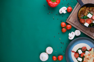 Fototapeta na wymiar Raw ingredients for pizza or salad. Tomatoes, mushrooms on green background. Flat lay. Web design banner with copy space