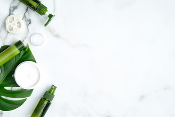 SPA natural organic cosmetic products with monstera tropical plant leaves on marble background....