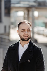 Naklejka premium Portrait of fashionable well dressed man with beard posing outdoors