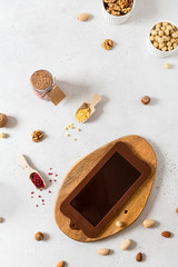 Homemade chocolate in mold. Chocolate bar, nuts, dried fruits on white background top view. Chocolatier, confectionery. Organic chocolate