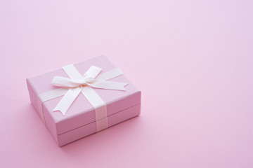 Top view of pink gift box with bow ribbon on pink background and copy space. Credit card reward point, cash back, bonus for special member concept. Business financial shopping sale promotion.