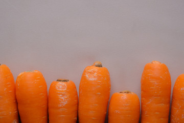 Top flat lay overhead view of fresh raw carrot with pastel background and copy space. Close up shot