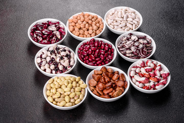 Pulses health food selection in white porcelain dishes over concrete background