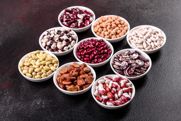 Pulses health food selection in white porcelain dishes over concrete background