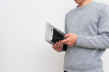 PC片手にスマホ操作する男性