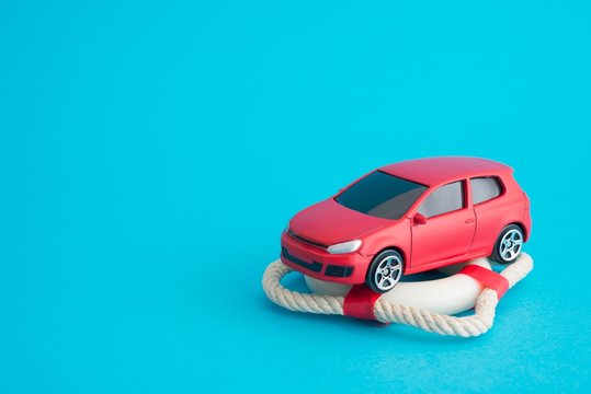 Red Car On Lifebelt With Blue Background With Copy Space. Auto Insurance Business Concept. Check Car Insurance Quote For Get The Best Deal. Cover Life, Property Damage, Injury Of Third Party.