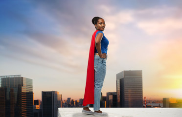 women's power and people concept - happy african american woman in red superhero cape over grey background