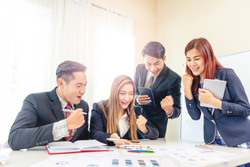 asian businessmen and business women looking at the work documents of statistics, working together in teamwork, planning strategies and decision making for business or company to progress and succeed