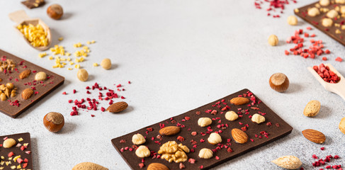 Milk and dark chocolate bars with nuts and dried fruits chocolate candies on white background,...