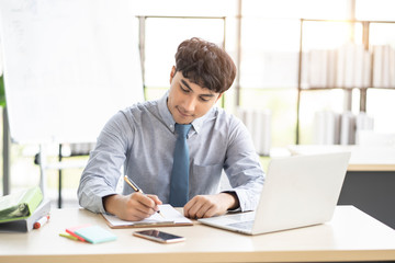 asian businessman employee working in modern office, using pen writing on clipboard researching information, concept of working corporate company planning, brainstorming business ideas and strategies