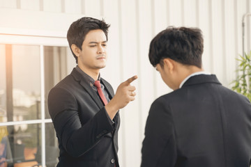 asian businessman entrepreneur executive in stress anger mad pointing at employee or colleague working on table desk in modern office supporting and help concept of organization in business strategy