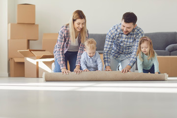 Happy family with carpet on the floor in a new apartment.