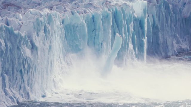 Ice of glacier collapsing to the lake. Slow motion
