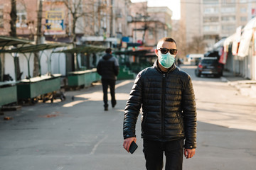 Coronavirus. Man wearing medical protective mask walking on street.  Corona virus COVID-19. Air pollution, virus, Chinese pandemic concept. Virus, pandemic, panic concept.