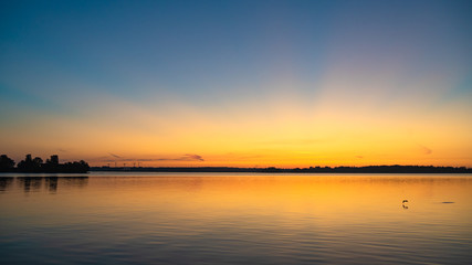 Fototapeta na wymiar Golden sunbeams reflecting on the sea at sunrise