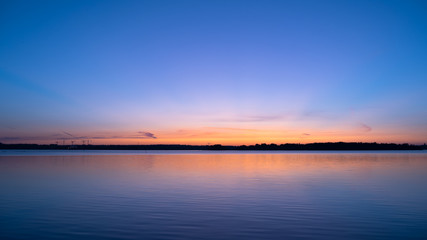 Fototapeta na wymiar Sky at dawn and peaceful lake; beautiful view of sunrise