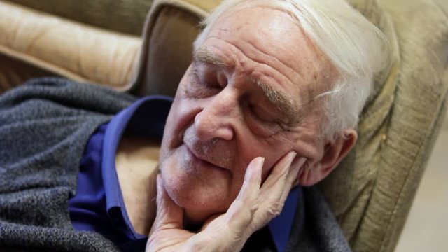 84 Year Old Poorly White Elderly Man Close Up Portrait Sitting Down Hand On Face.