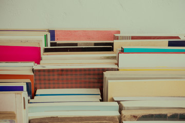 Stack of many old books background on table in book store or library room, vintage tone. Knowledge learning, education, bachelor degree in university or back to school concept.