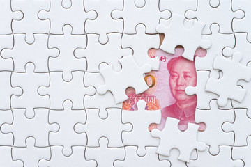 Chairman Mao zedong on Chinese yuan banknote under unfinished white jigsaw puzzle. China or world economy crisis situation due to US - China trade war concept