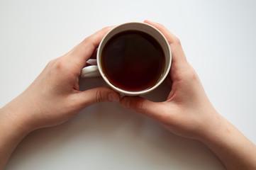 women's hands holding a coffee mug top view on an isolated white background