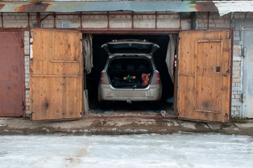 garage space with an open gate with a car inside