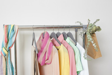 Spring fashion - pastel colored clothes on rail. Female colorful bright spring clothing set of on the racks on white background. Sale at clothing store concept.