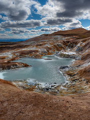 Beautiful colourful Icelandic landscape lava fields mountain geysers zigzag road and moss-covered stones Namafjall, Iceland.
